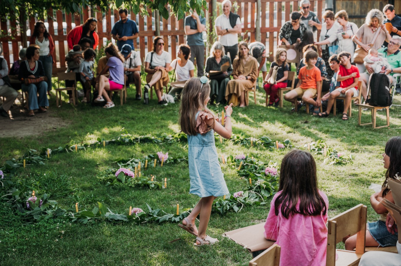 Niños participando en la ceremonia de Micael con velas y flores