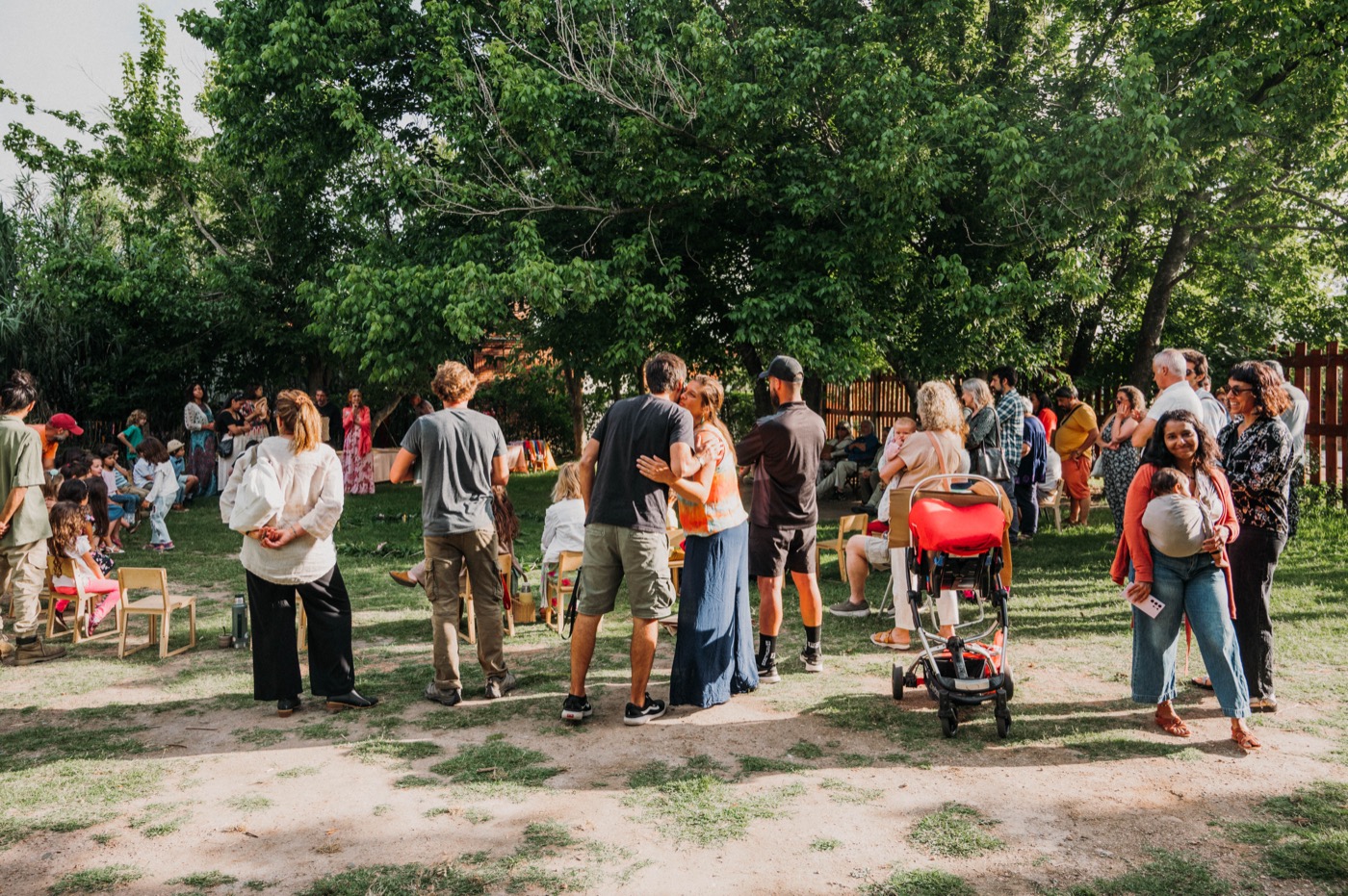 Familias de la comunidad reunidas en el jardín de la escuela