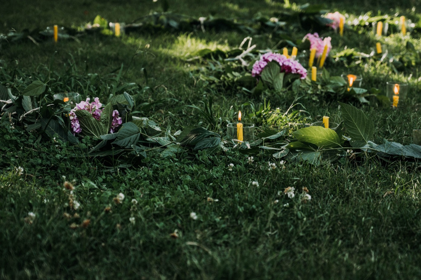 Velas y flores sobre el pasto en una festividad de la escuela