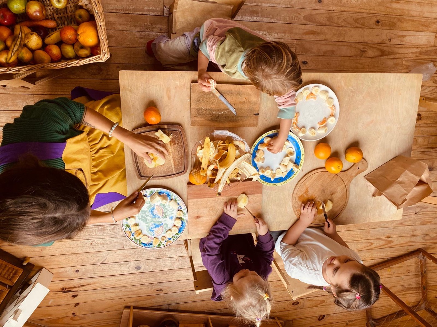 Niños preparando alimentos con su maestra en el Jardín