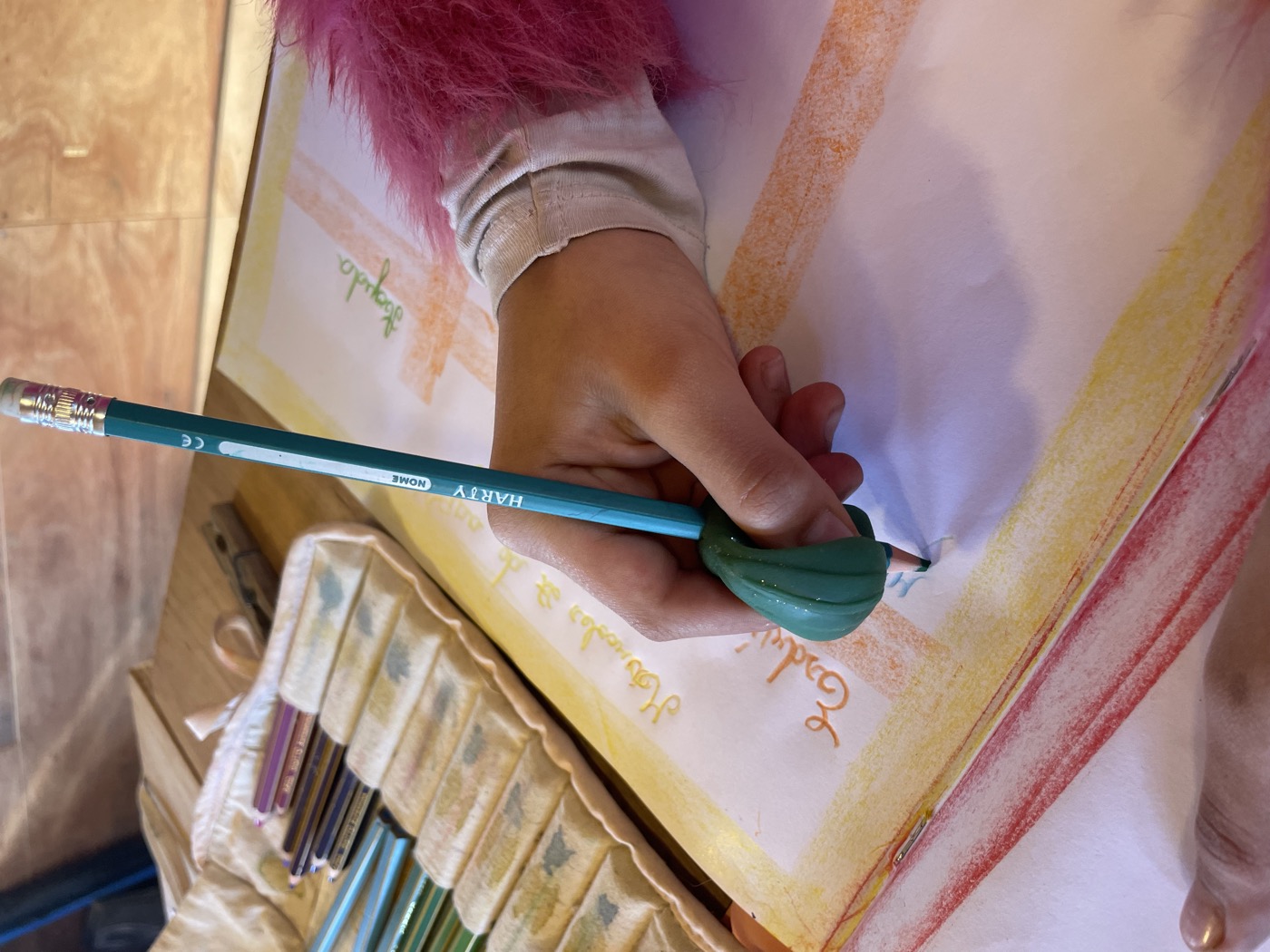 Mano de niño escribiendo en su cuaderno de época