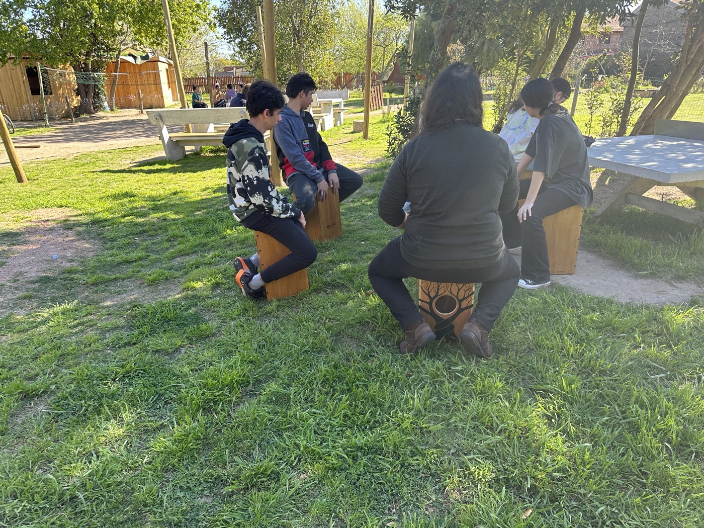 Jóvenes tocando cajón en el espacio exterior de la escuela